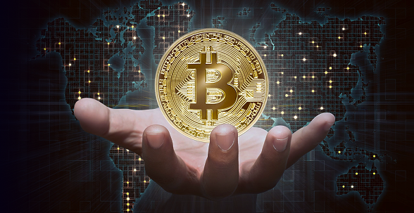 Main présentant bitcoin sur fond numérique mondial